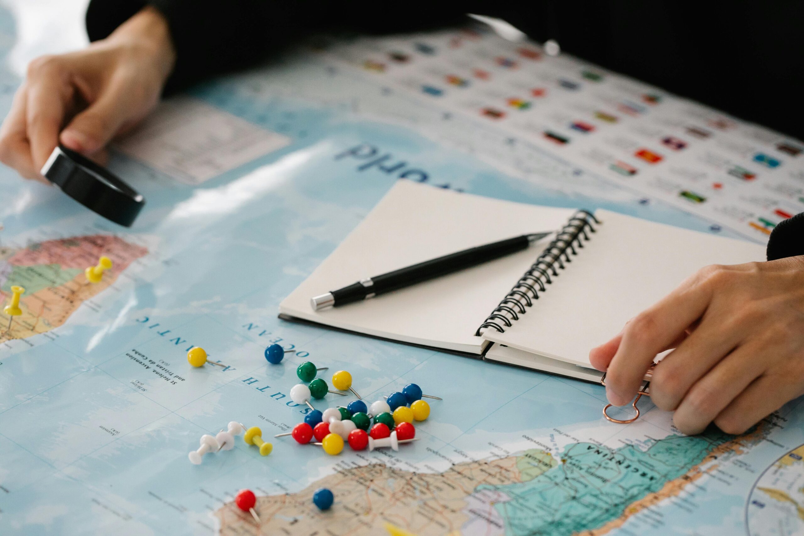 A traveler organizing her itinerary for a luxury bus trip using a laptop and notebook.