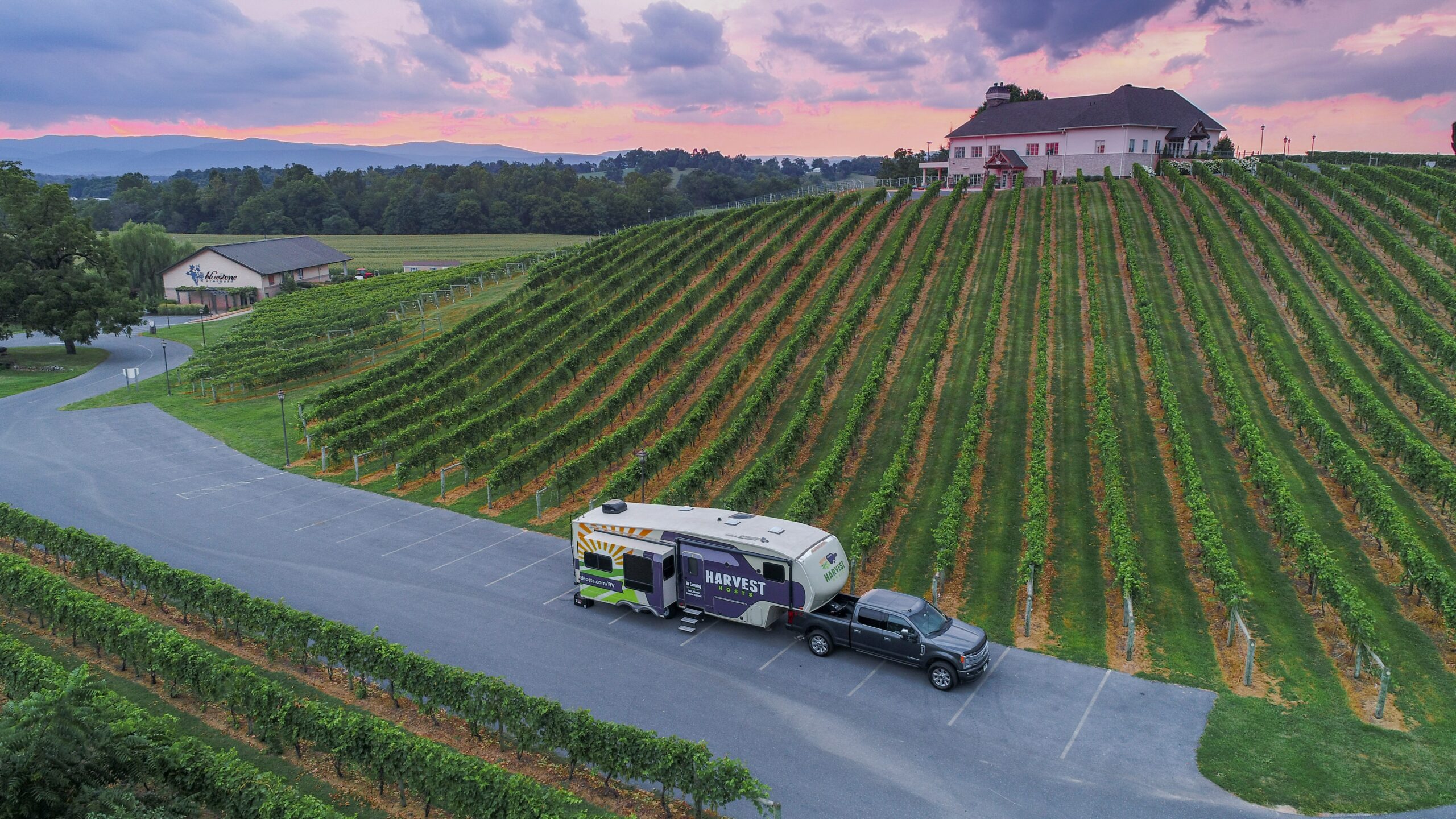 Luxury bus passing vineyards during sunset