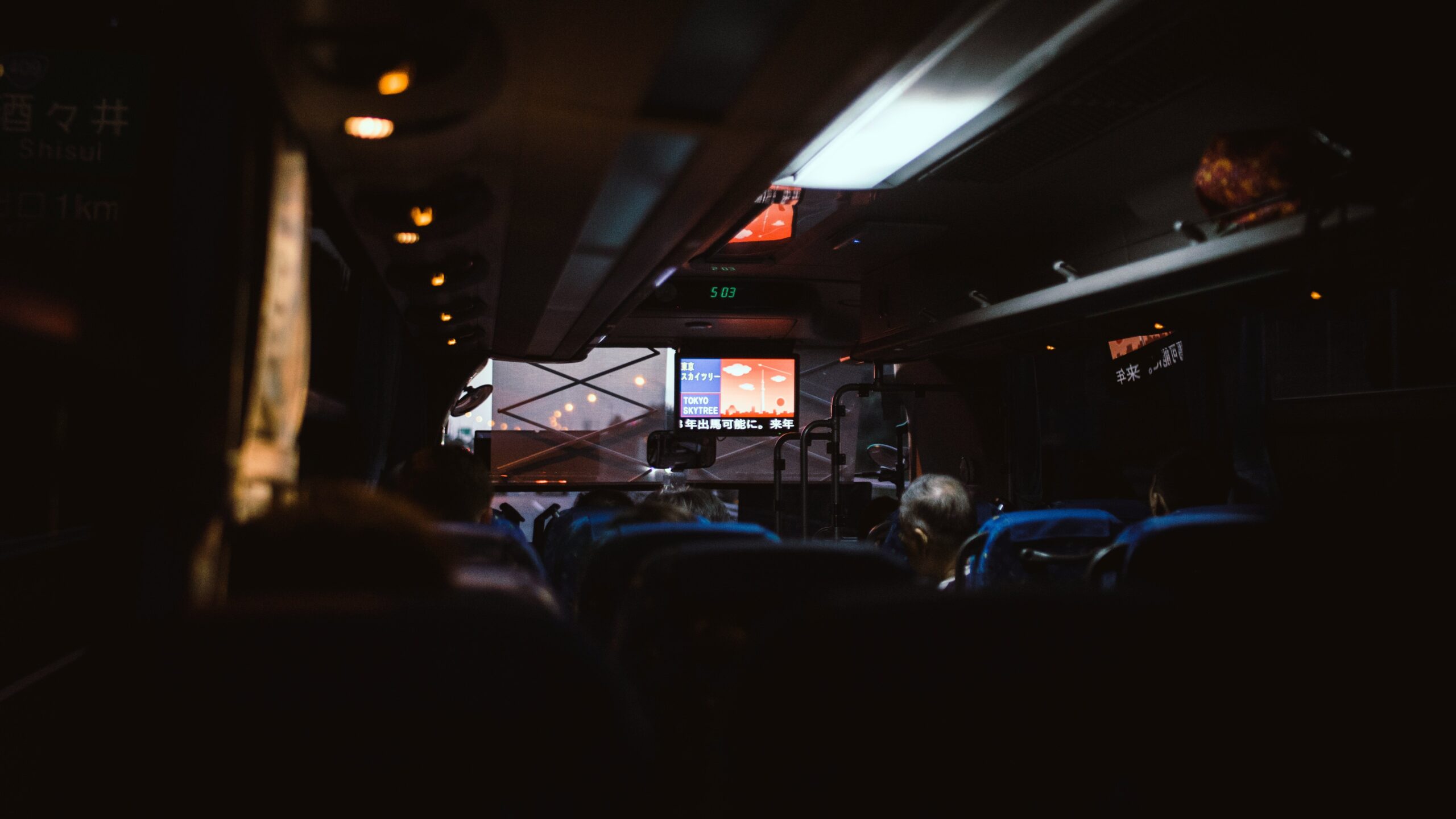 Interior view of a first-class elite bus showcasing comfortable leather seats, panoramic windows, and elegant lighting.