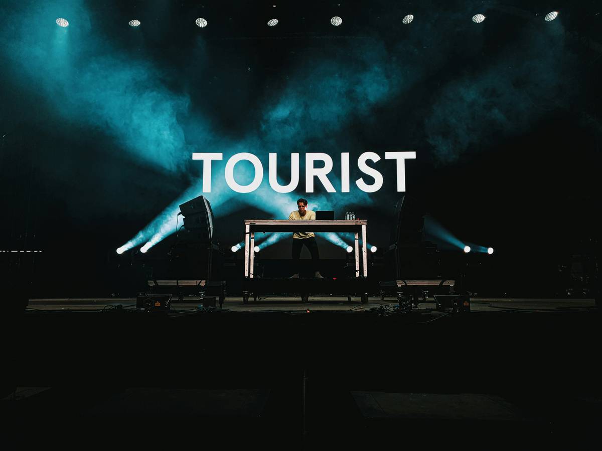 A luxury bus parked near a scenic coastal viewpoint surrounded by mountains.