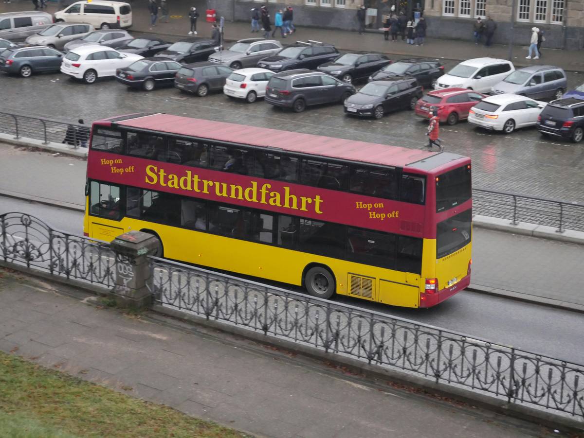 Group photo of smiling passengers aboard a luxury bus enjoying refreshments.