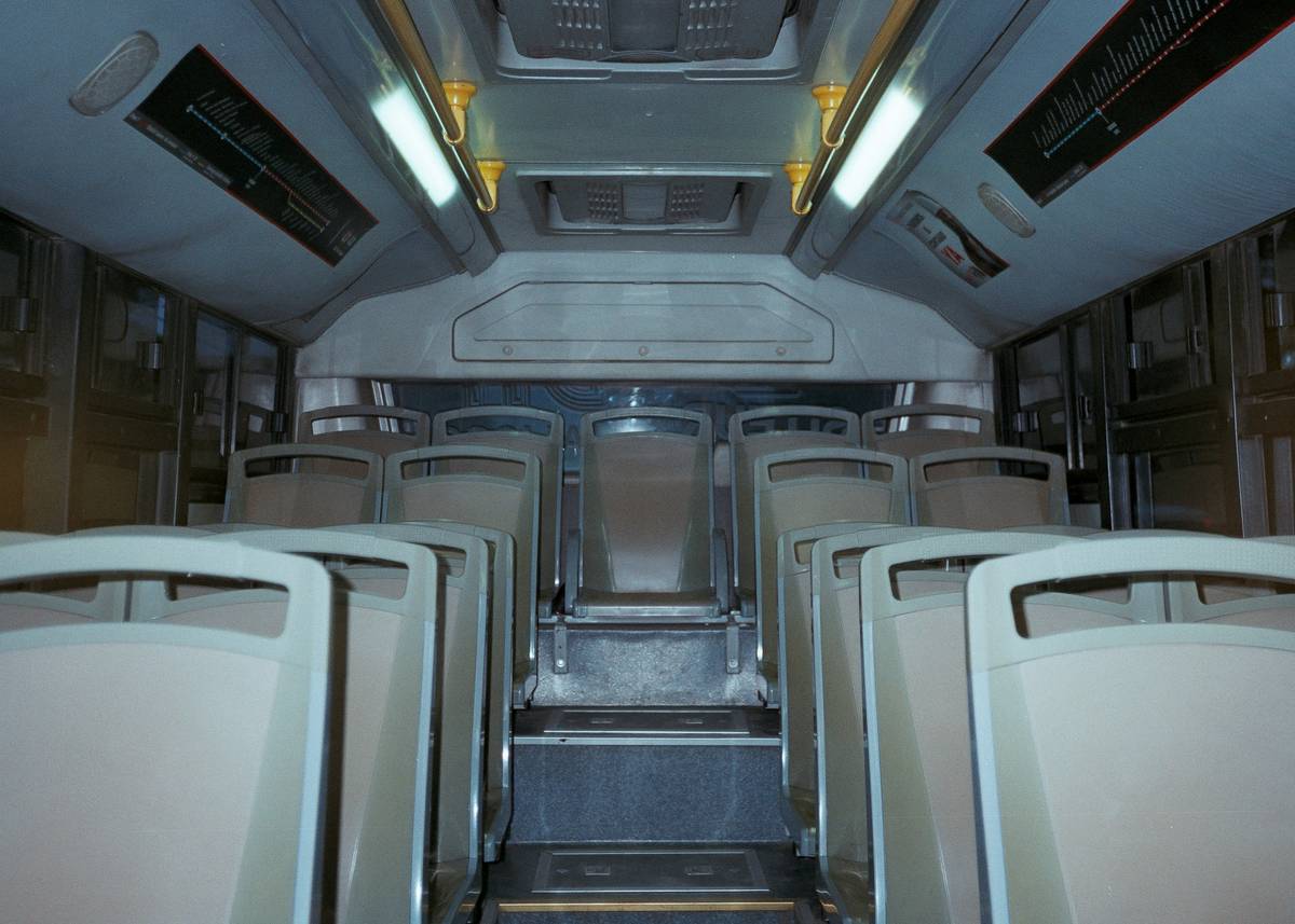 Interior of a luxurious tour bus featuring reclining leather seats and ambient lighting