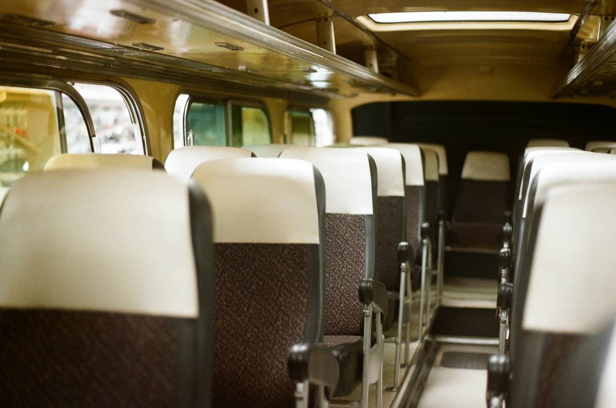 A luxurious bus interior featuring plush leather seats and wide windows.