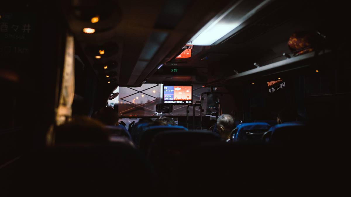 A modern luxury bus interior featuring plush seating and ambient lighting