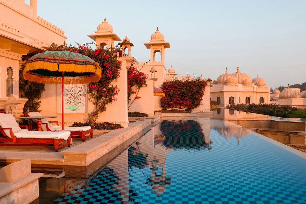 A large swimming pool with a lounge chair next to it