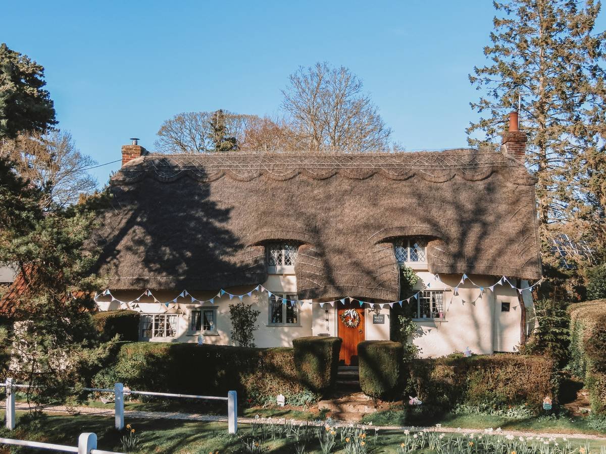 Easter bunting on picturesque 17th Century thatched cottage. Arkesden, Essex.
