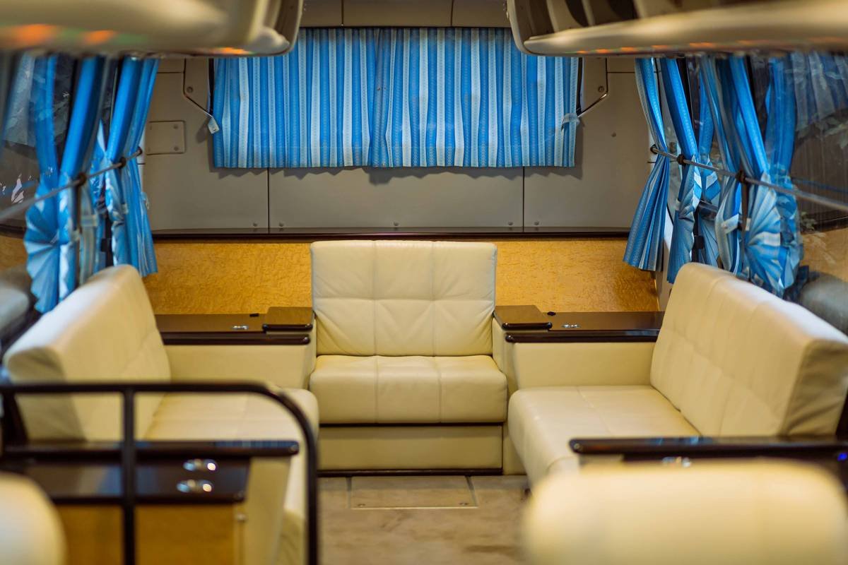 Infographic comparing standard vs. true deluxe bus tour features: seat width, guide expertise, itinerary design, and hidden fees