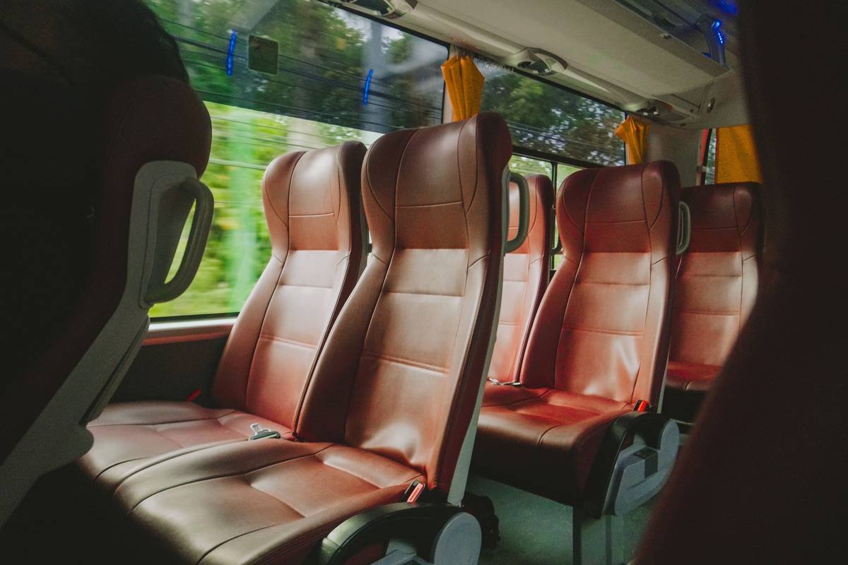 Interior of a luxury Mercedes-Benz touring coach in Ireland with panoramic windows, reclining leather seats, onboard restroom, and digital entertainment screens