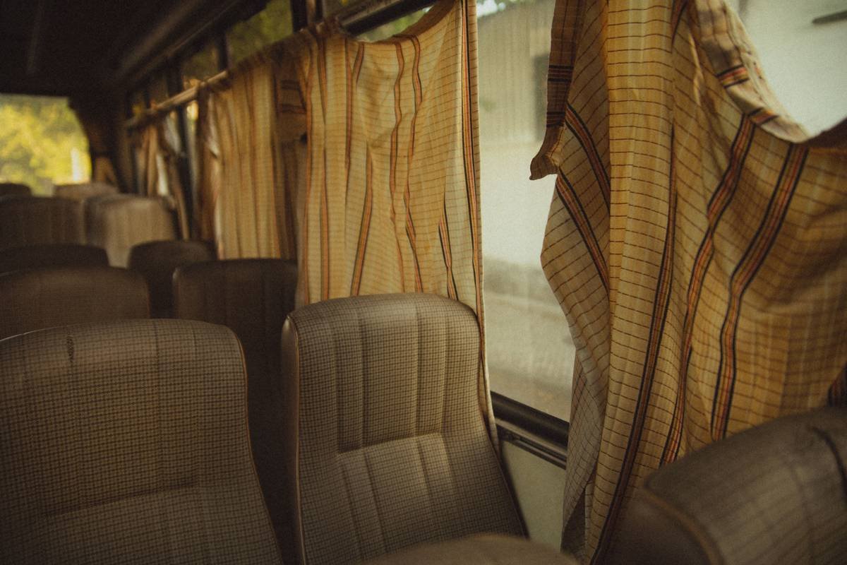 Infographic comparing standard luxury vs. first class charter bus features including seat pitch, HVAC systems, safety certifications, and tech amenities