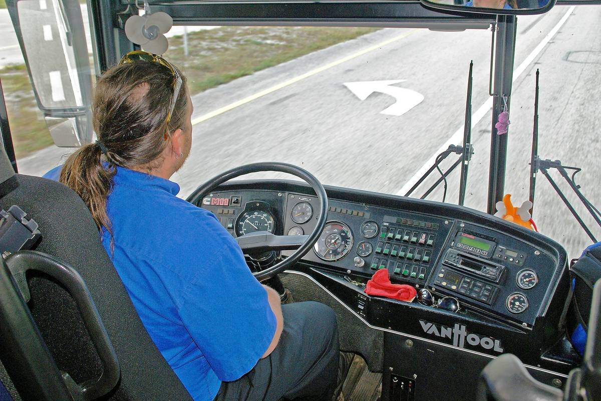 first student bus training tips: instructor demonstrating mirror adjustment on a luxury coach