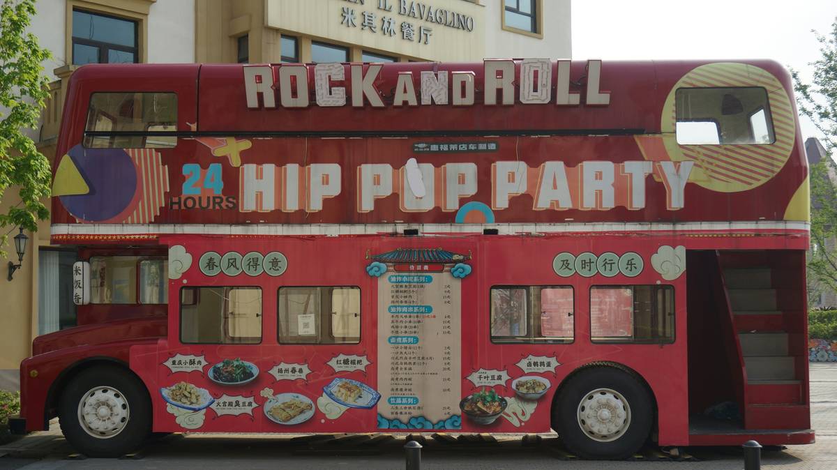 a red double decker bus parked in front of a building
