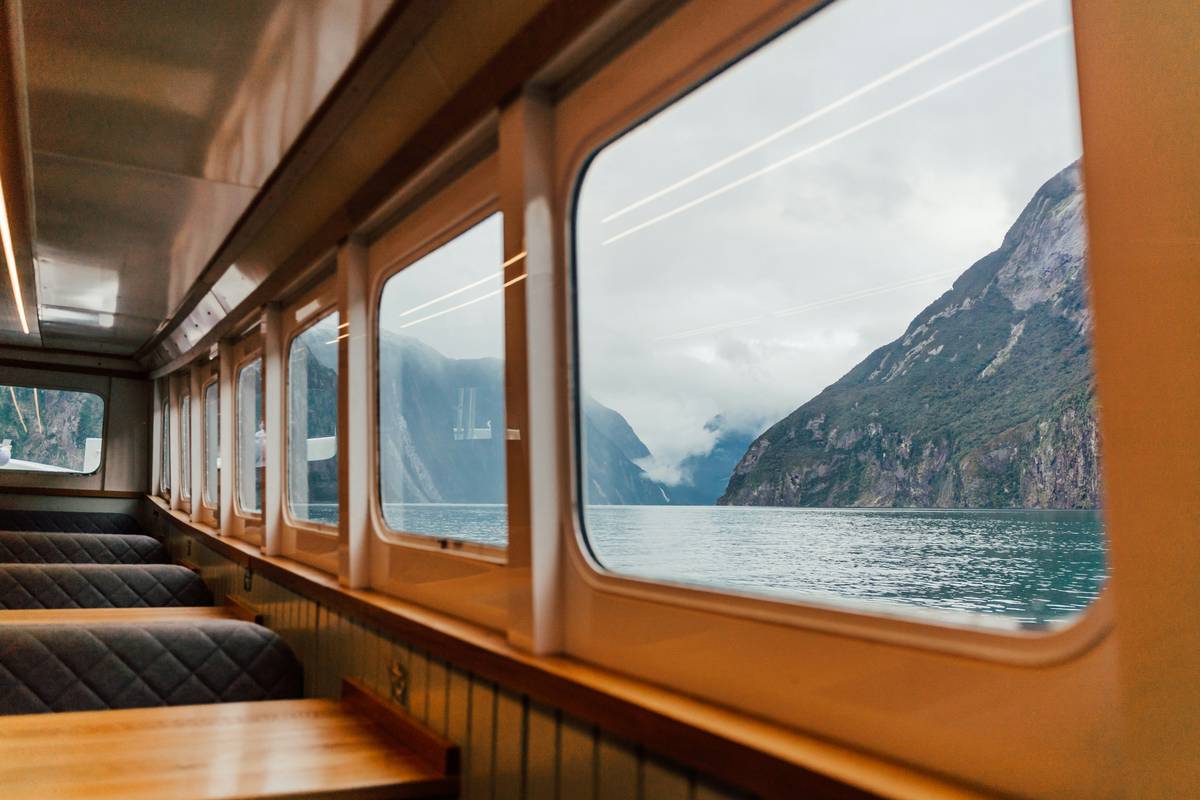 a train with a view of the mountains and the water